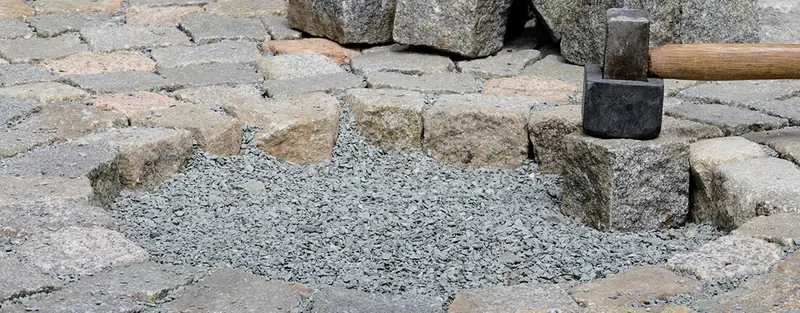 Gatsten som sätts i grus, stensättning i Linköping